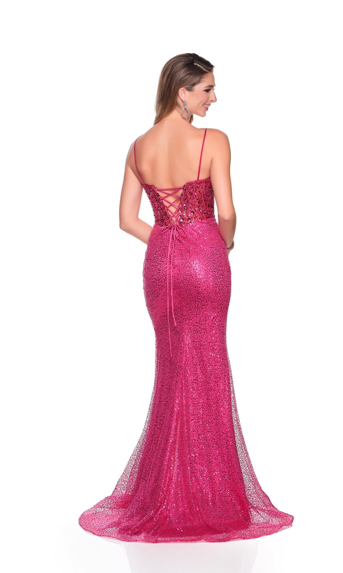 A woman faces away, wearing the Dave and Johnny 12450 long prom dress—sparkly fuchsia pink with a corset bodice, thin straps, lace-up back, and a fitted mermaid silhouette.